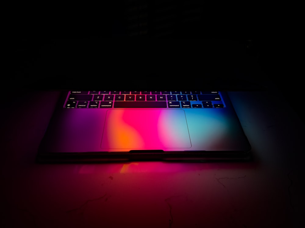 Un ordinateur portable avec un clavier coloré éclairé dans l’obscurité