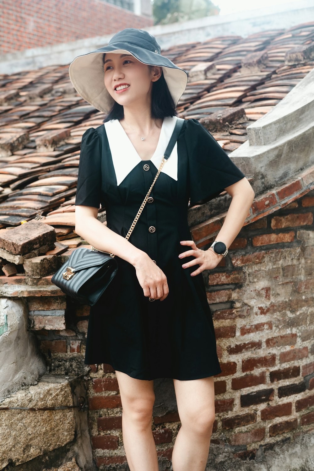 a woman standing next to a brick wall