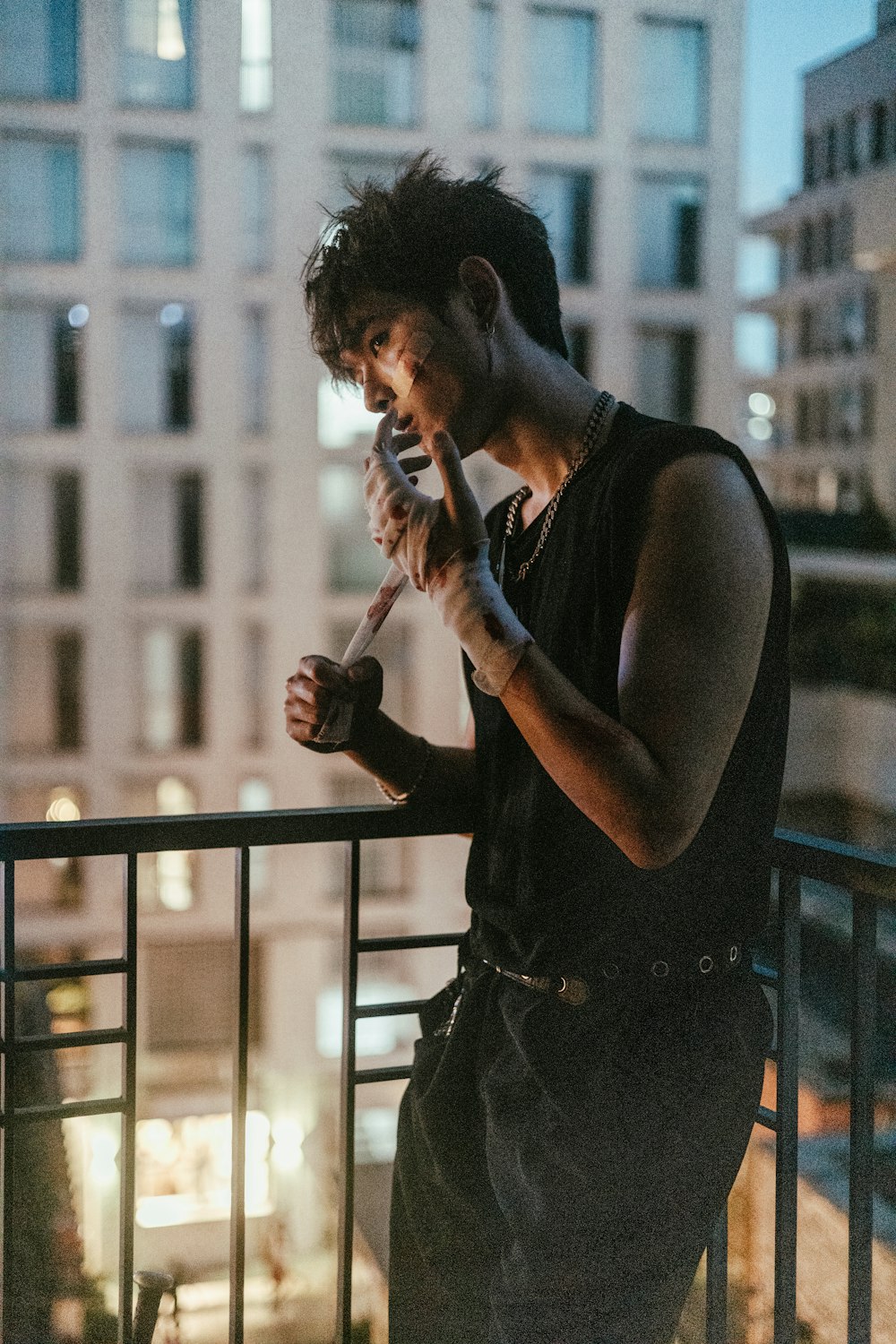 a man standing on a balcony smoking a cigarette