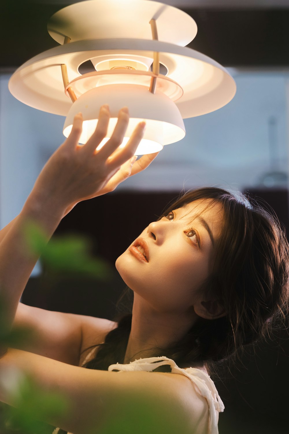 a woman holding a light above her head