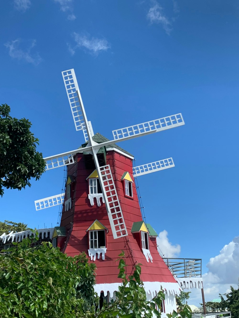 a red and white house with a windmill on top of it