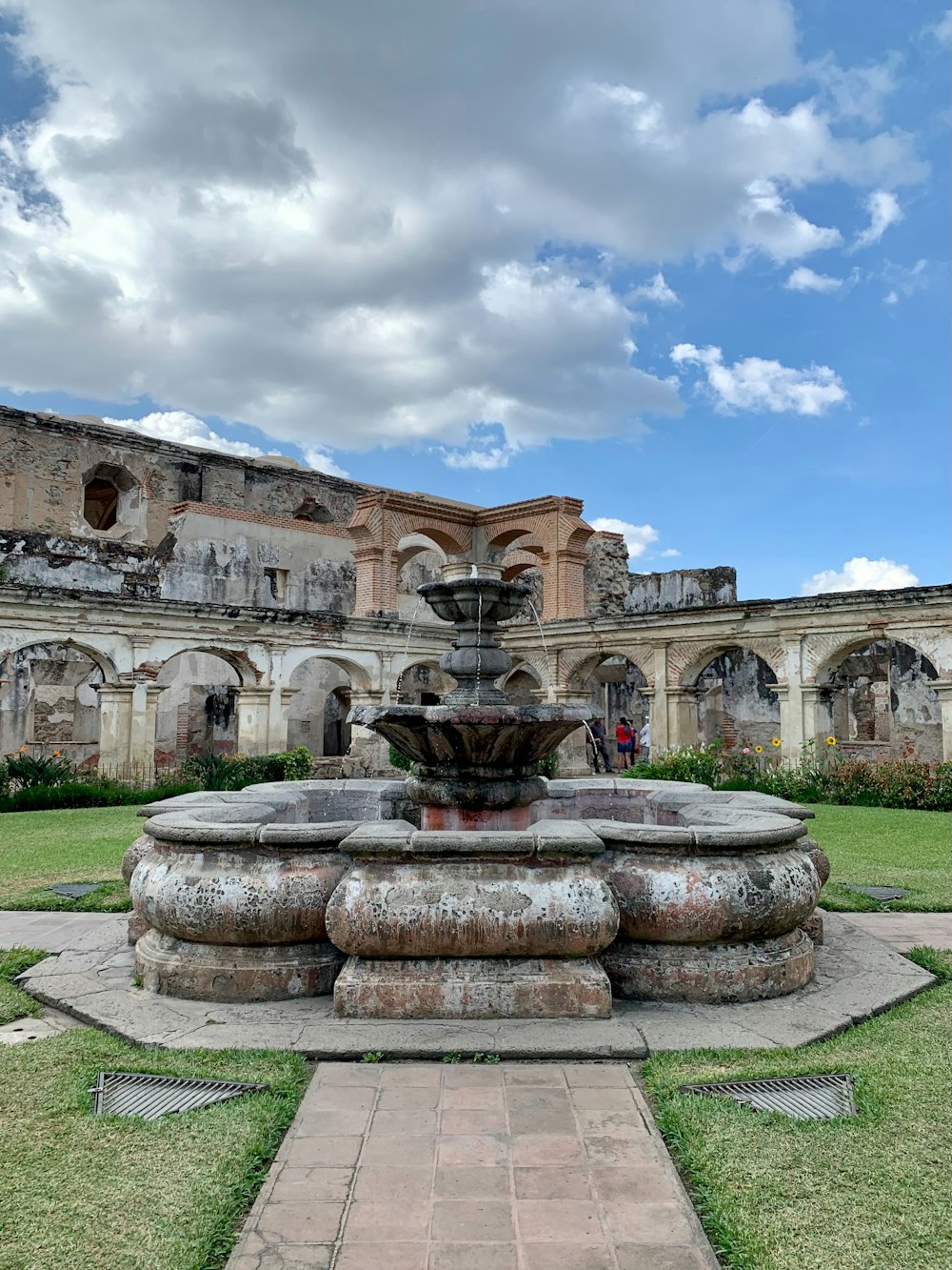 a stone fountain in front of an old building