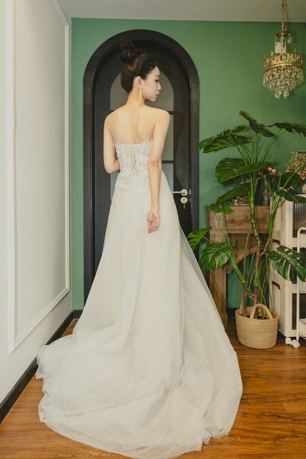 a woman in a wedding dress standing in front of a door