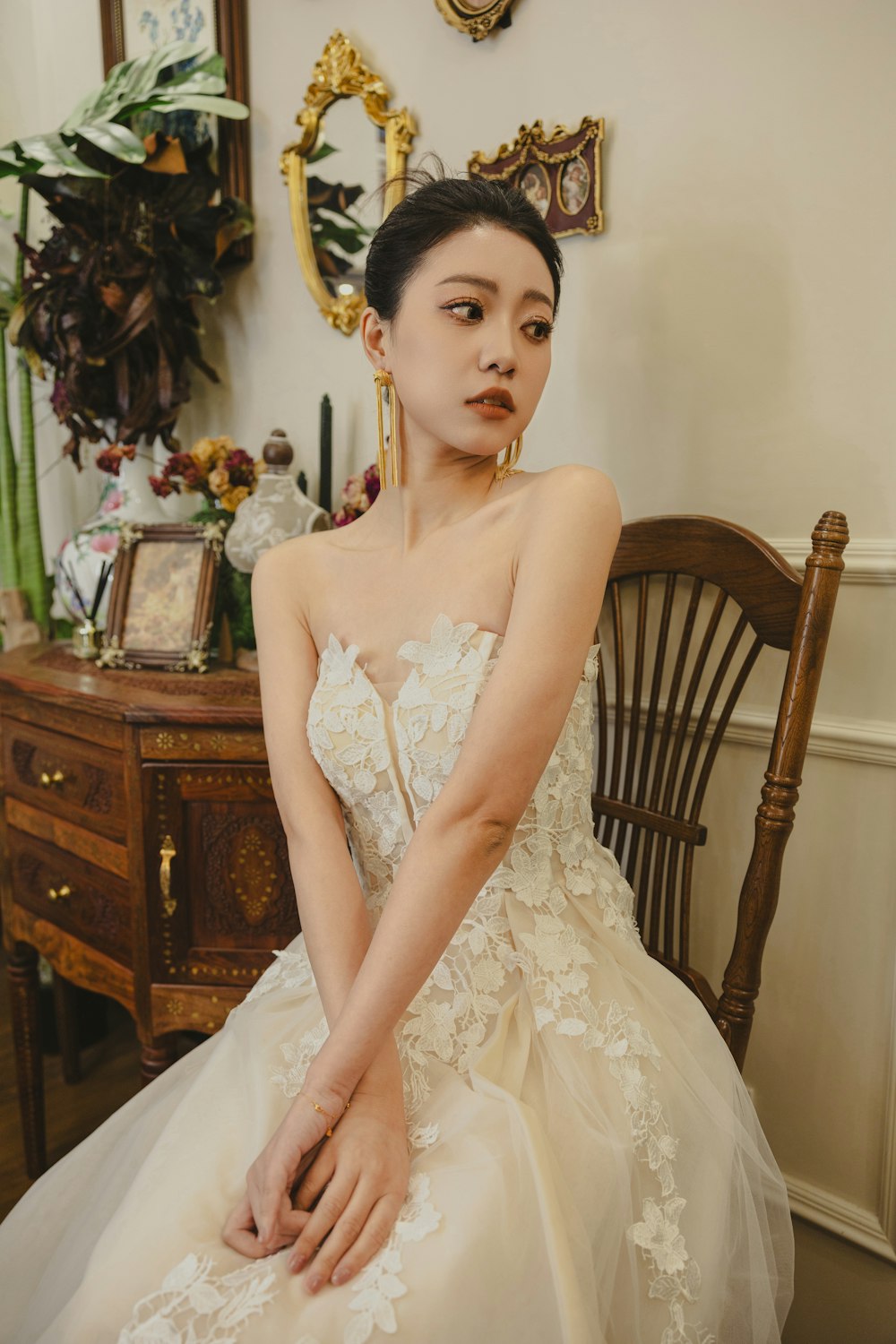 a woman in a wedding dress sitting on a chair