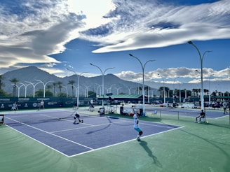 a group of people playing tennis on a tennis court
