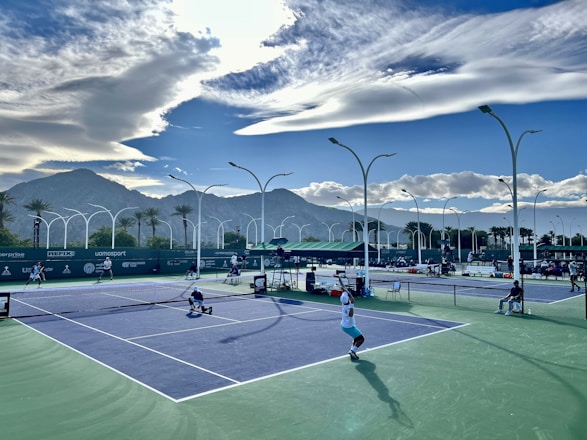 a group of people playing tennis on a tennis court