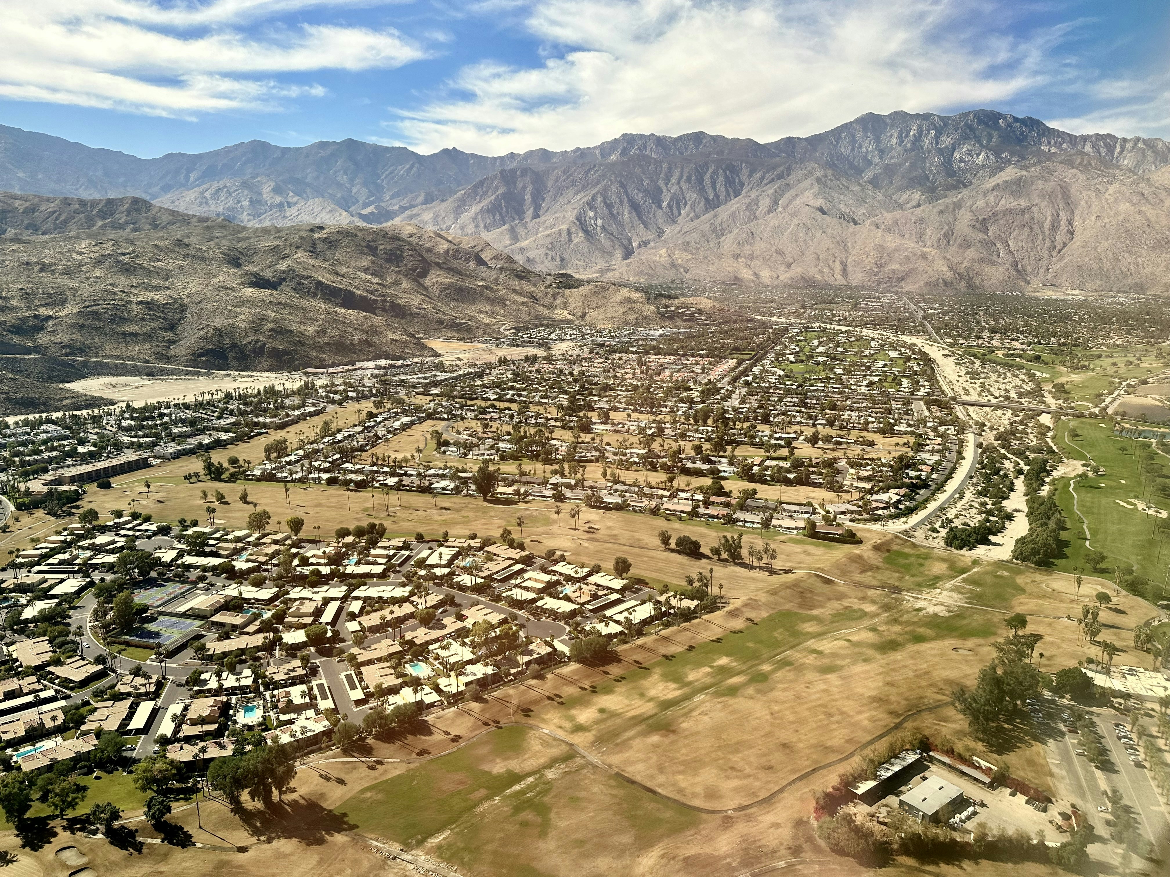 Palm Springs and Coachella Valley from the air with the San Jacinto Mountains and mid century modern architecture blue sky and clouds.