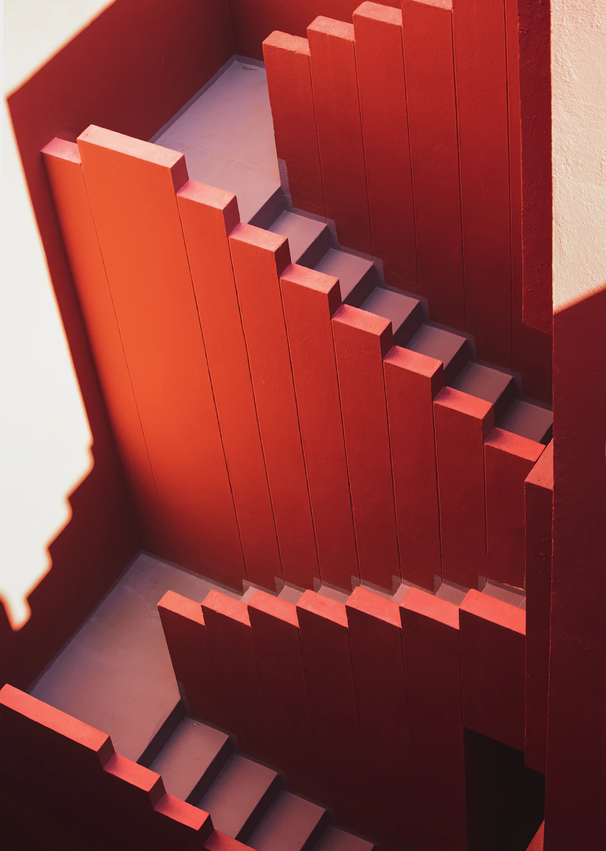A red staircase folding between red walls