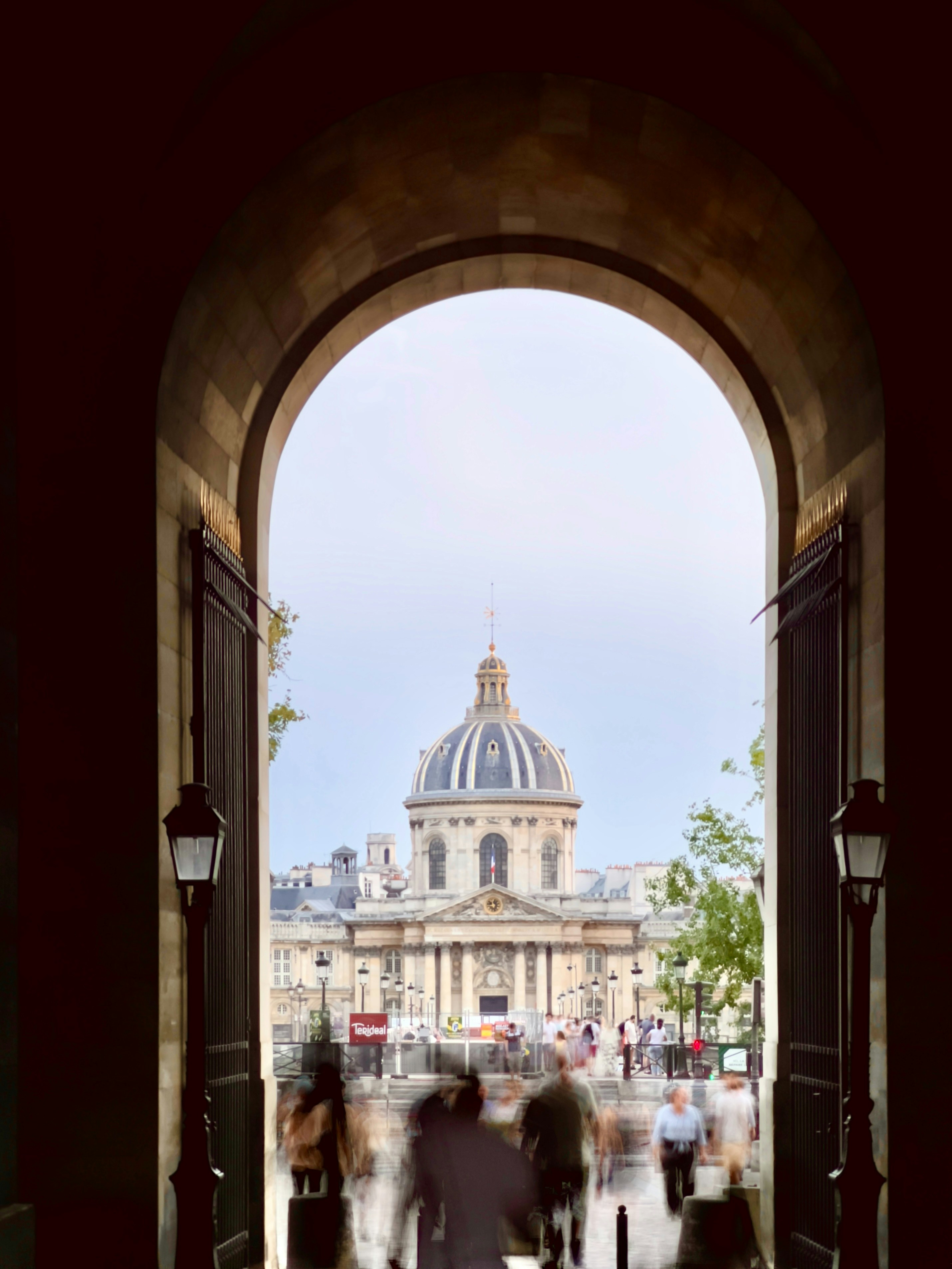 a group of people walking down a street next to a tall building
