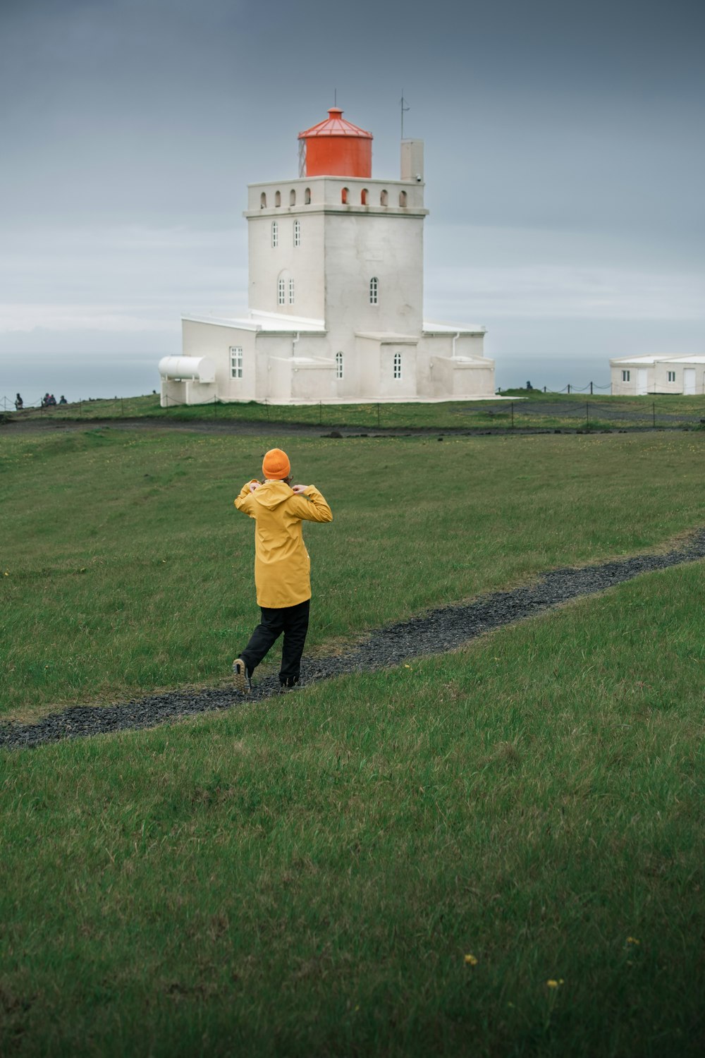 a person in a yellow jacket is flying a kite