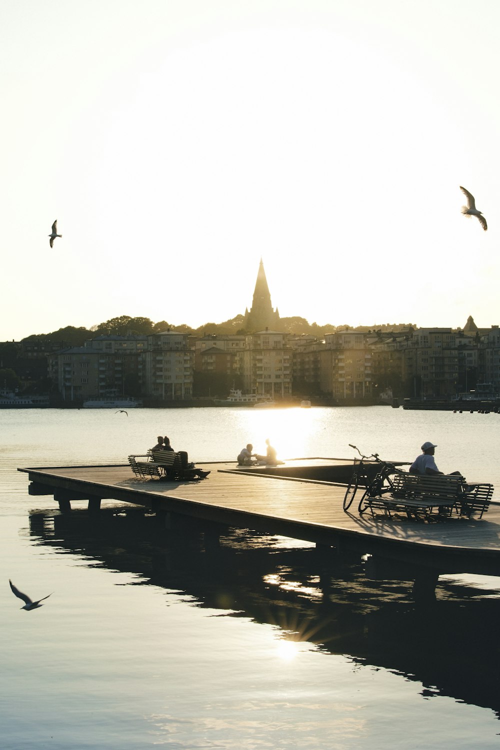 a couple of people sitting on a dock near a body of water