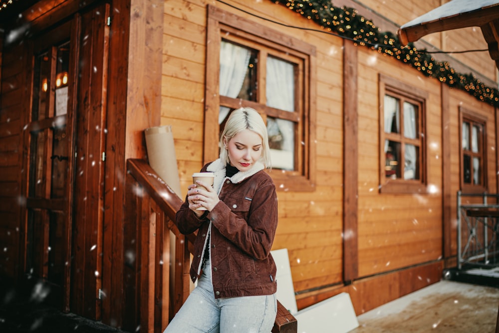 a woman standing in front of a wooden house