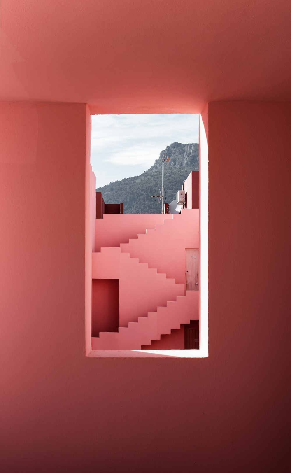 a pink room with a view of a mountain