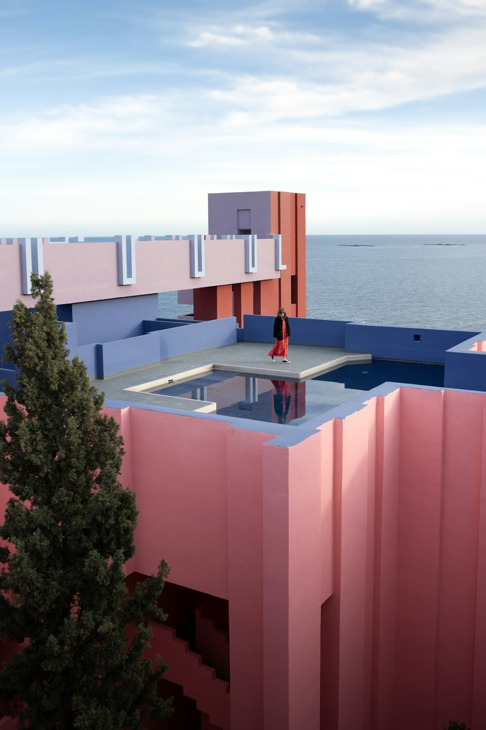 a pink building with a pool in the middle of it