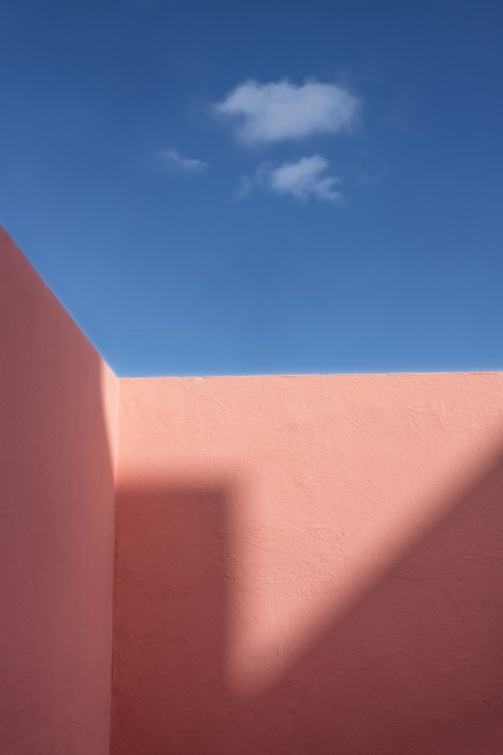 a pink wall with a blue sky in the background