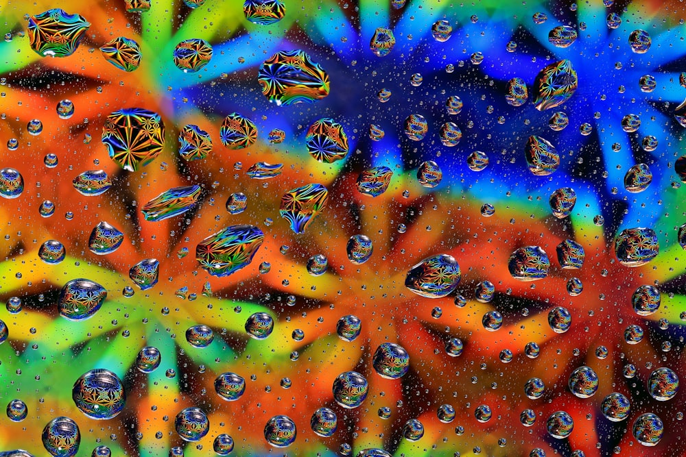 a group of drops of water on a colorful surface