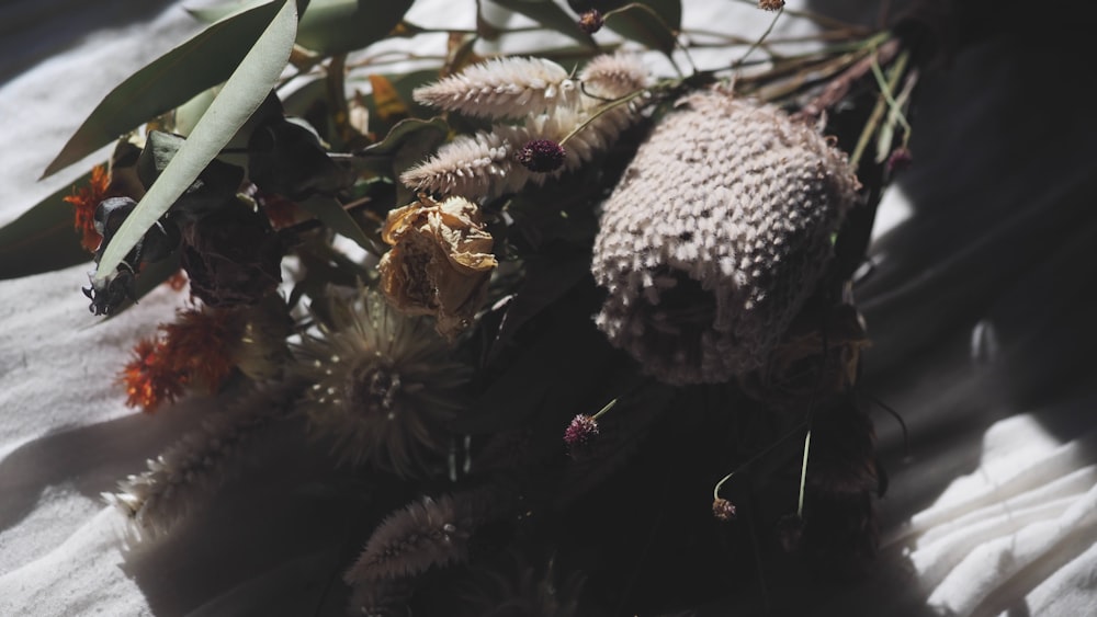 a bunch of flowers sitting on top of a white sheet