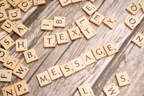 a close up of scrabble letters on a wooden surface