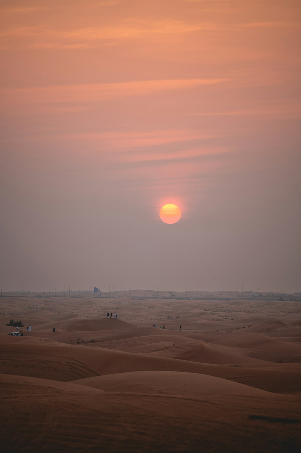 the sun is setting over a desert landscape