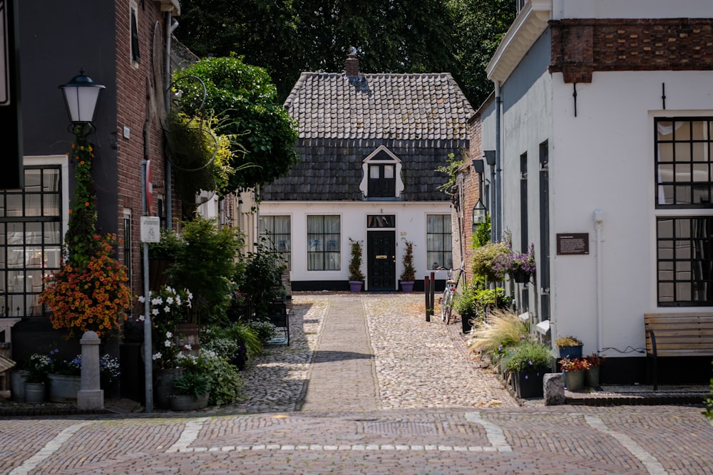 a cobblestone street with a white house in the background