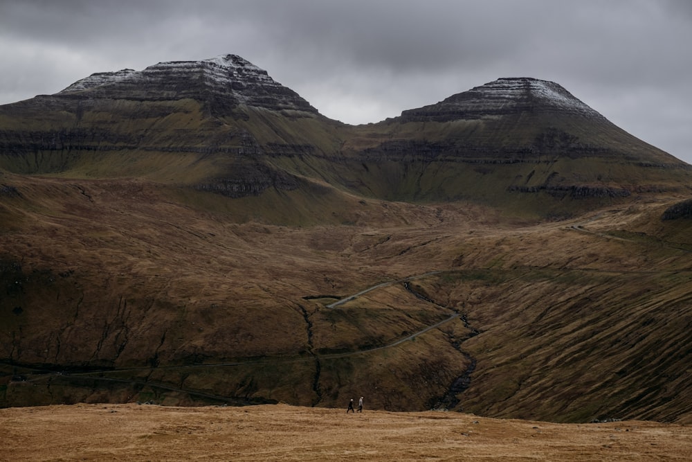 a couple of people standing on top of a hill