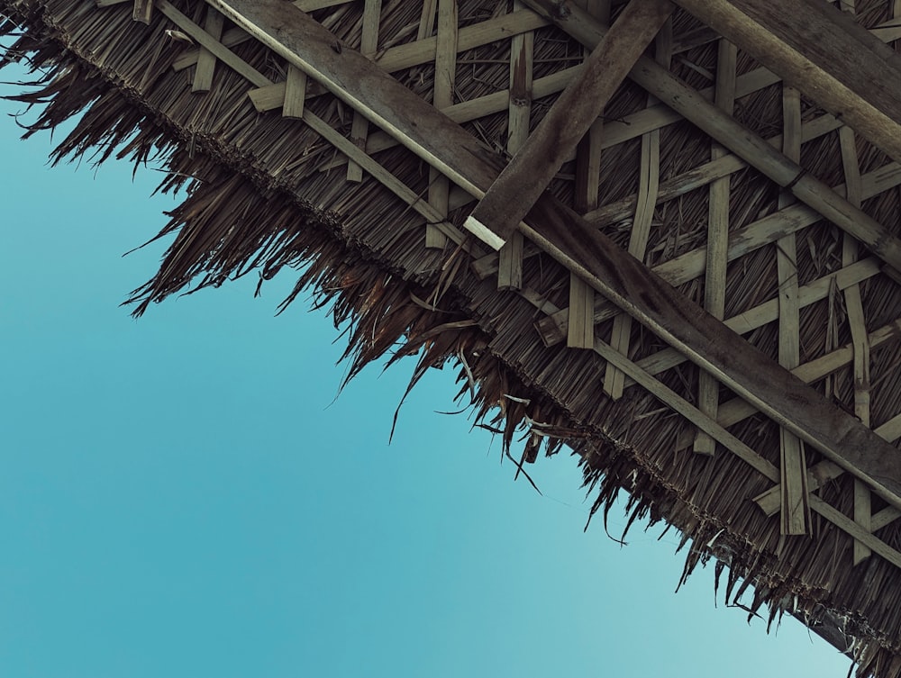 a thatched roof with a blue sky in the background