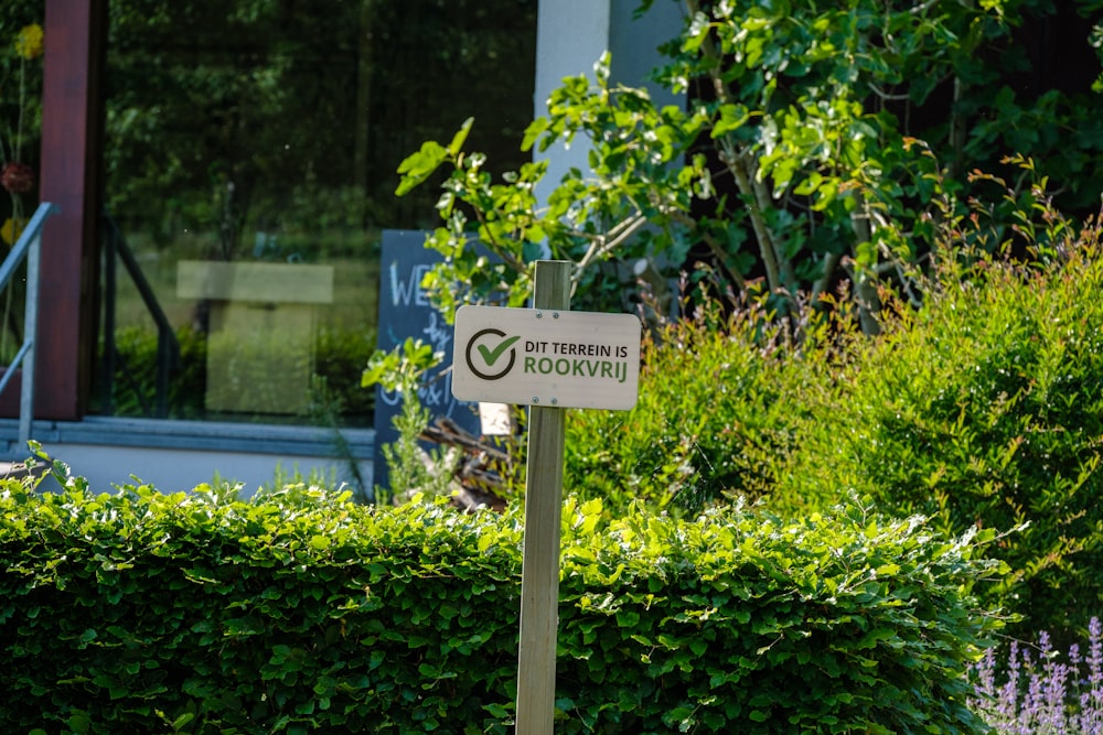 a street sign in front of some bushes