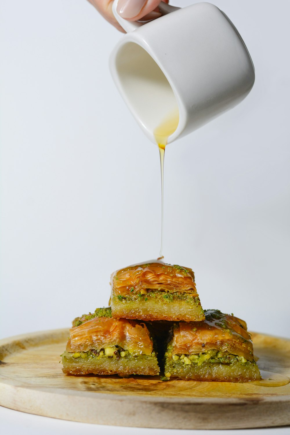 a person pouring sauce on some food on a plate