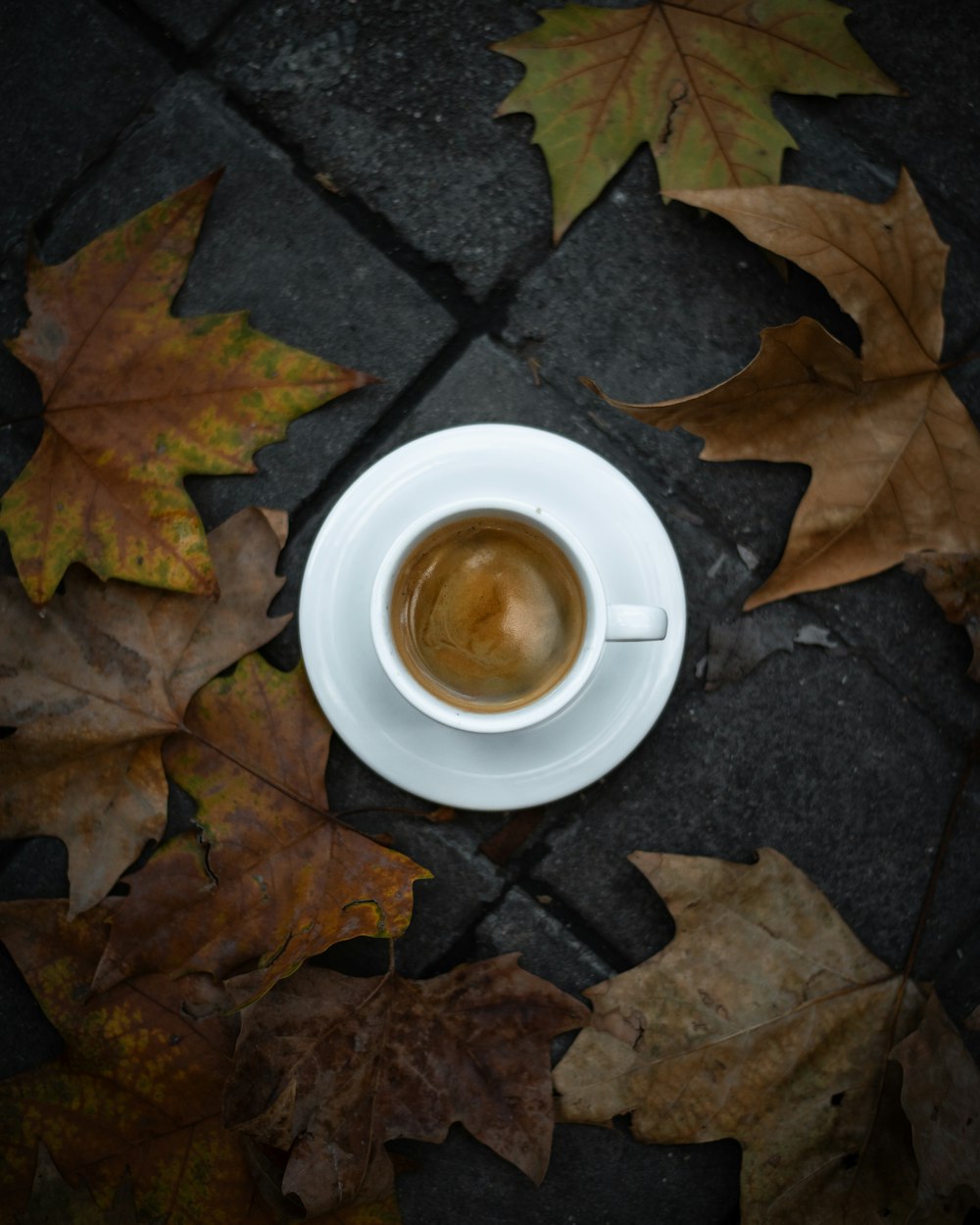 a cup of coffee sitting on top of a white saucer