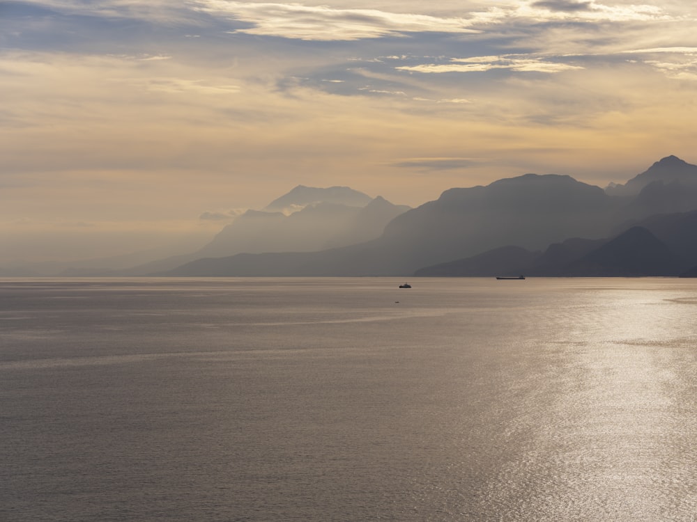 a large body of water with mountains in the background