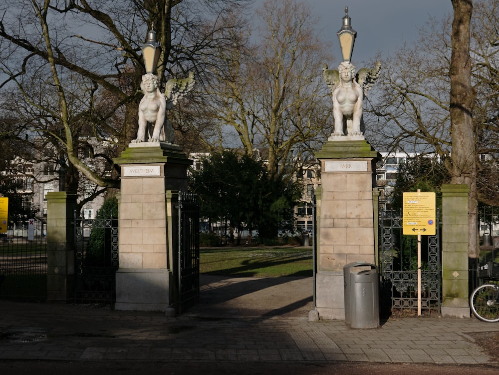 un couple de statues assises sur le dessus d’un trottoir