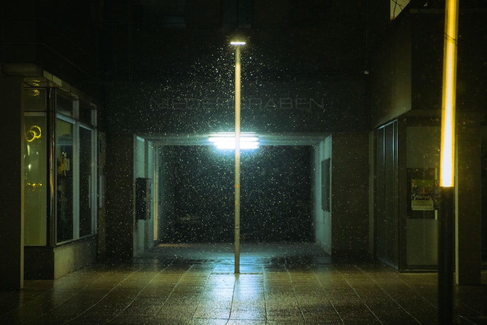 an empty street at night with a street light in the rain