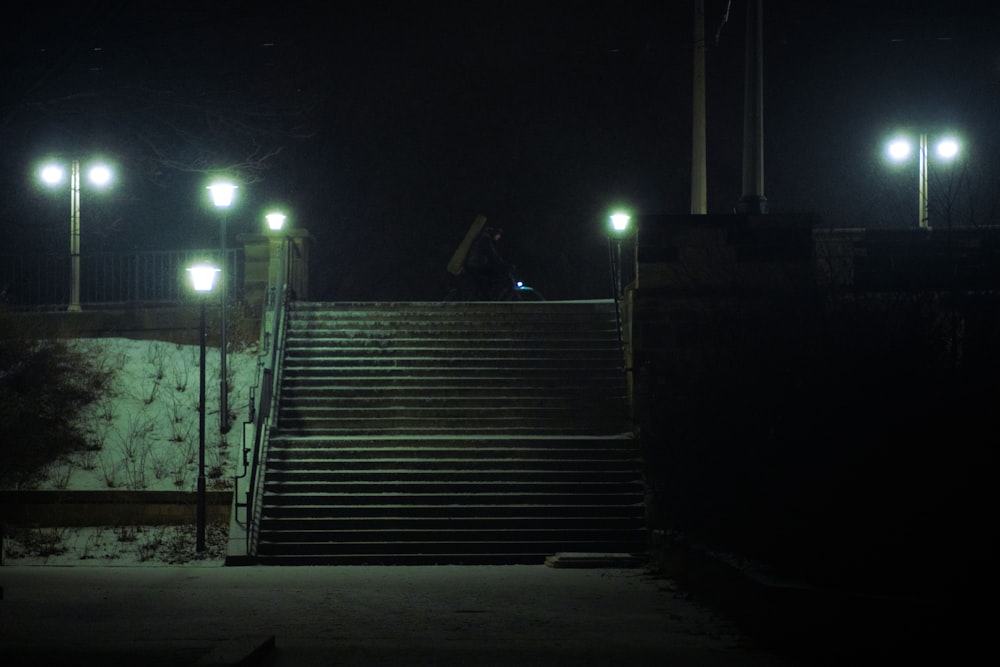 a man riding a skateboard down a set of stairs at night