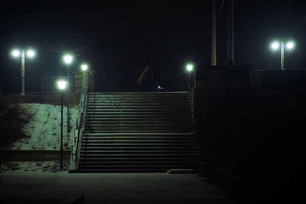 un uomo che scende una rampa di scale con uno skateboard di notte