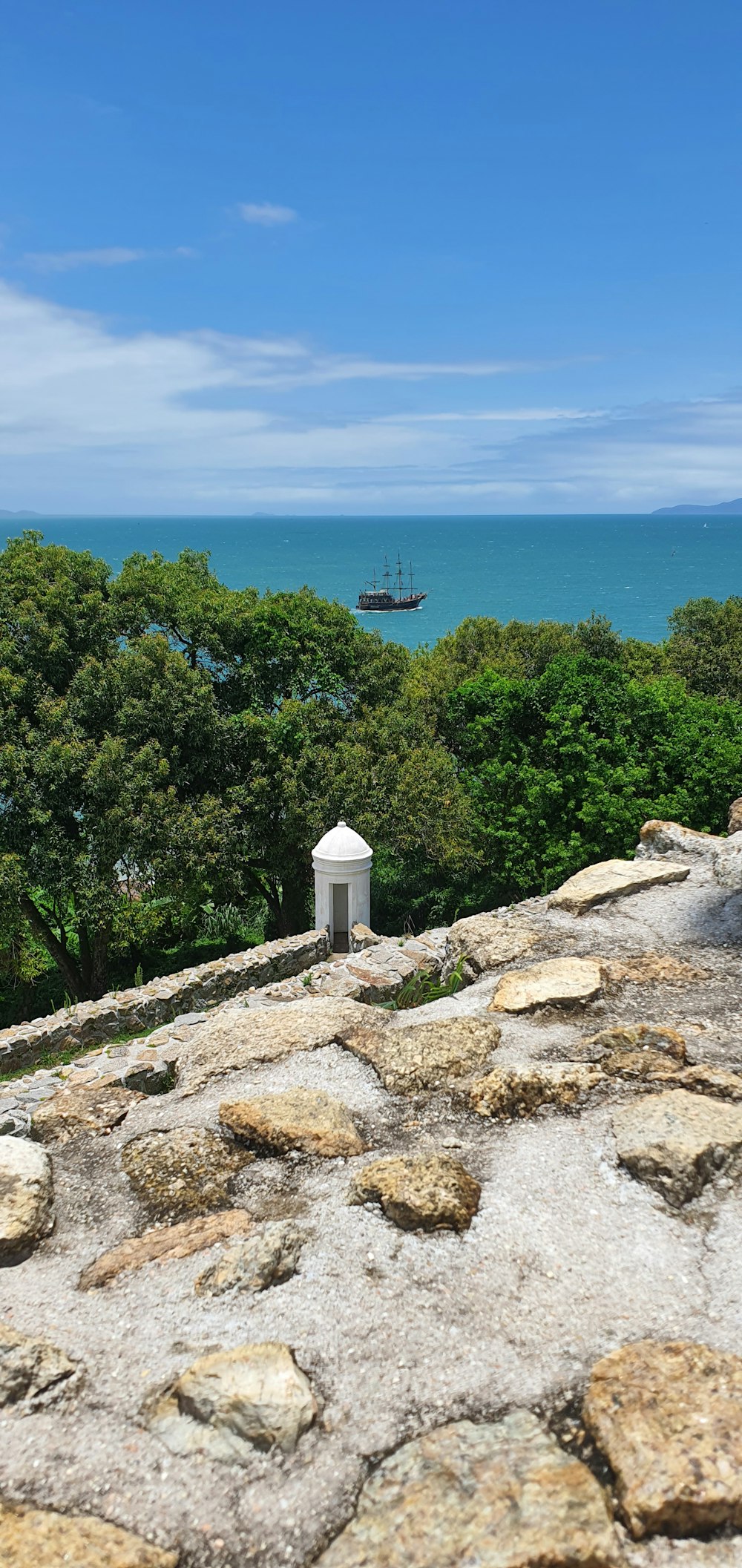 a bench sitting on top of a rock covered hillside