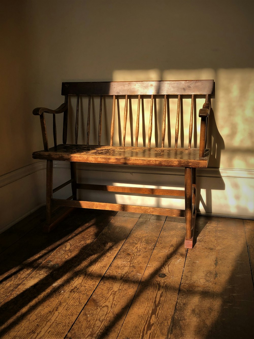 a wooden bench sitting on top of a hard wood floor