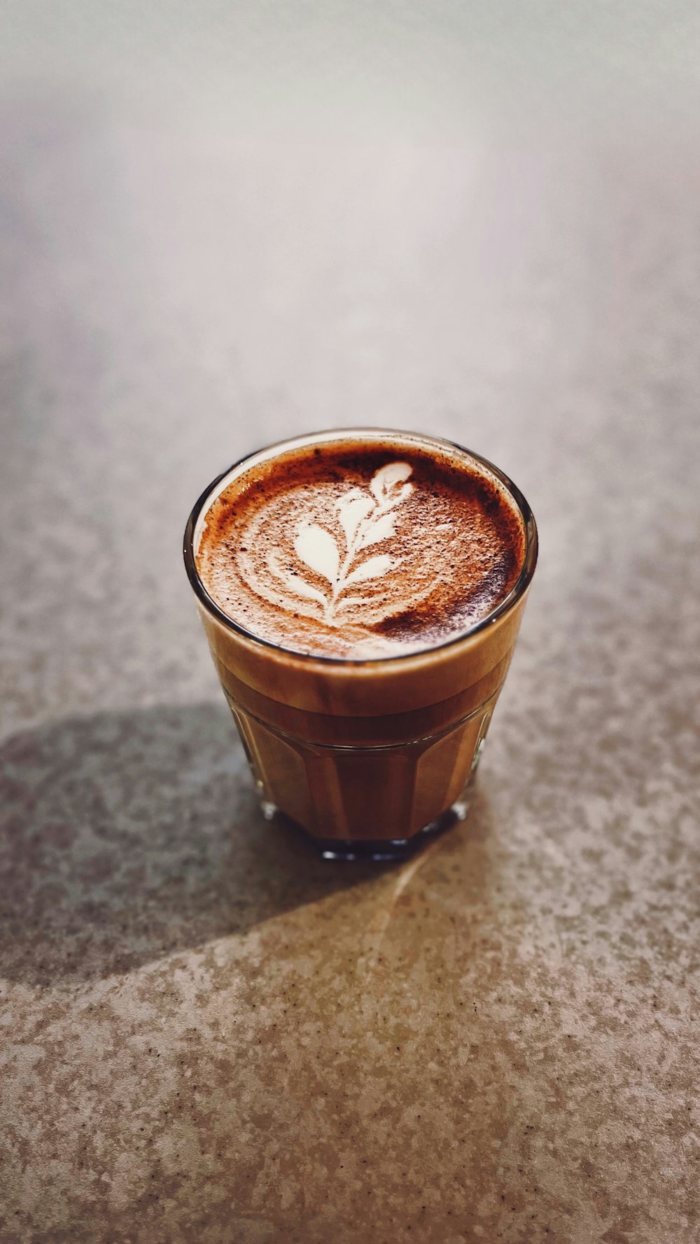 a cappuccino with a leaf on top of it