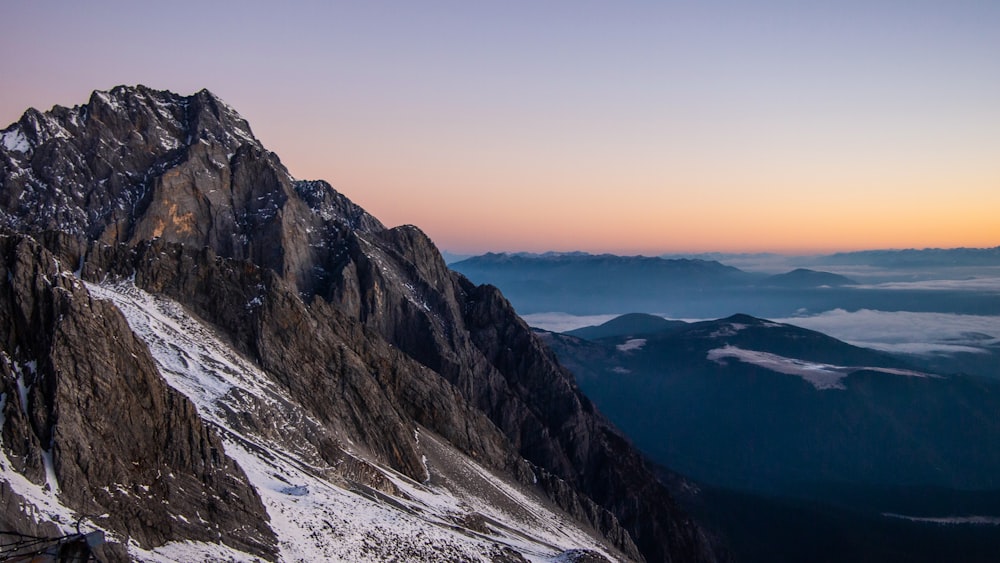 a view of the top of a mountain at sunset