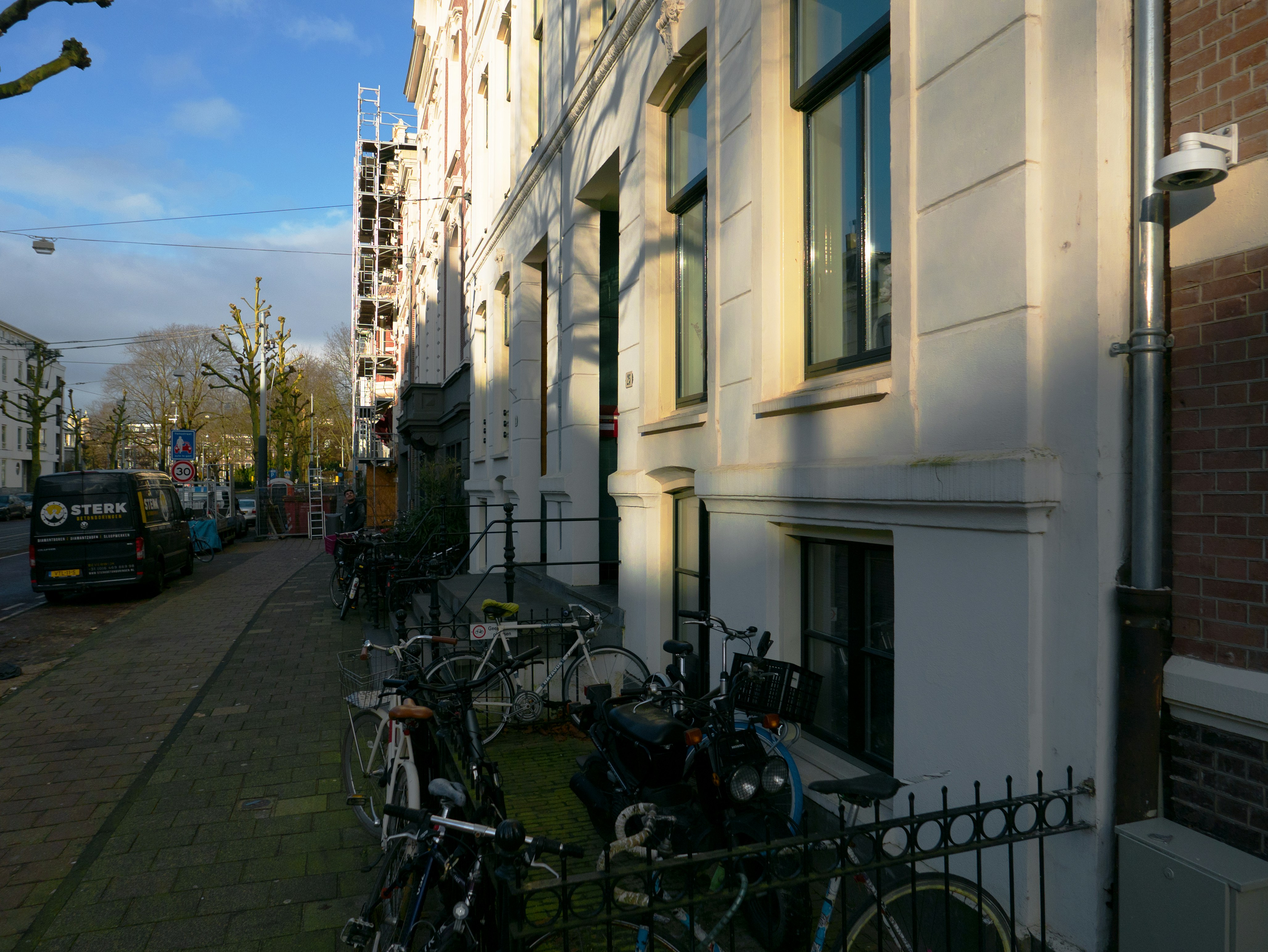a row of bikes parked on the side of a building