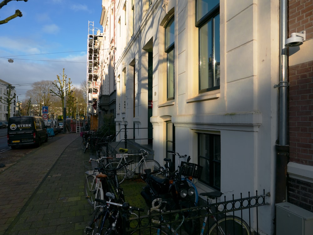 a row of bikes parked on the side of a building