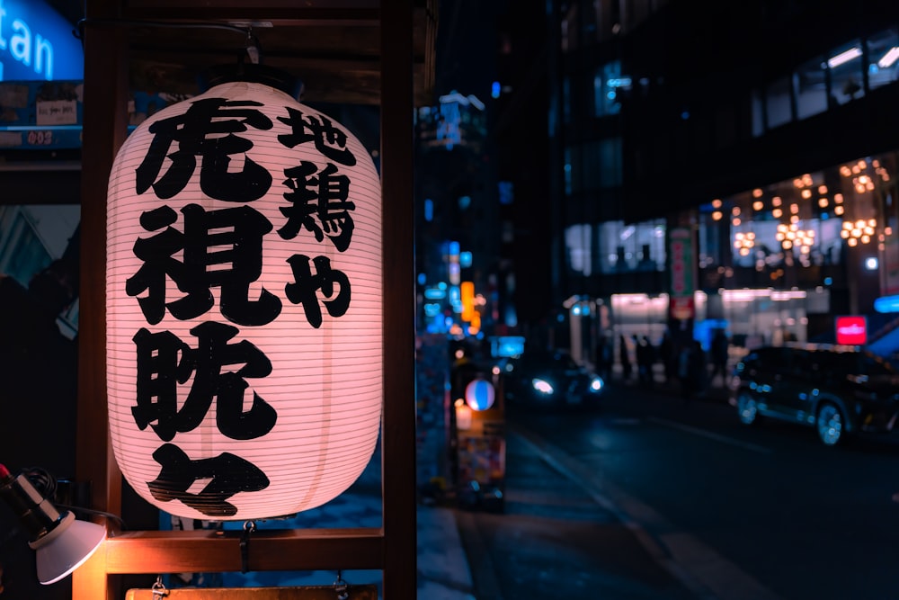a lantern with asian writing on it on a city street