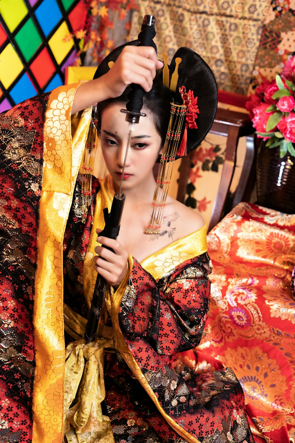 a woman in a geisha costume holding a black umbrella