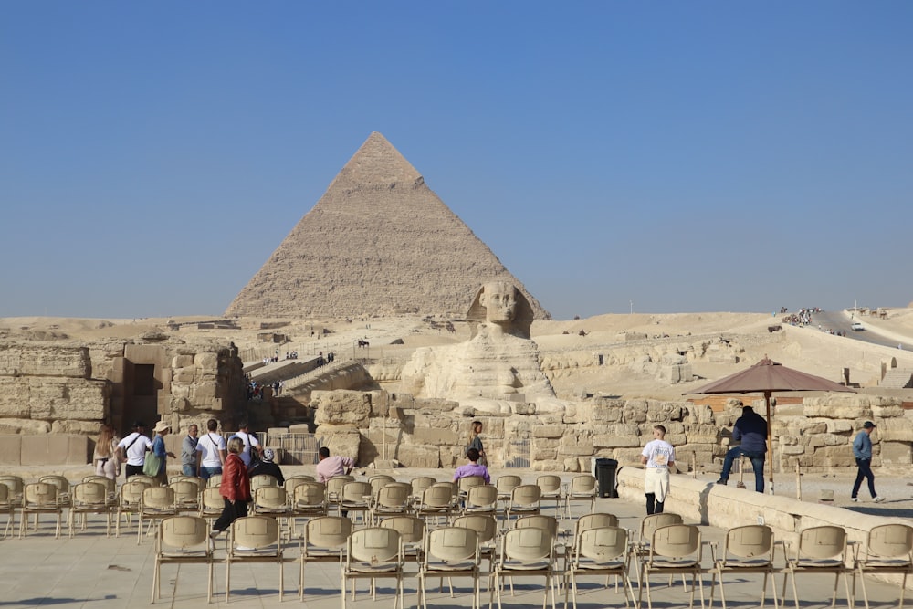 a group of people standing in front of a pyramid