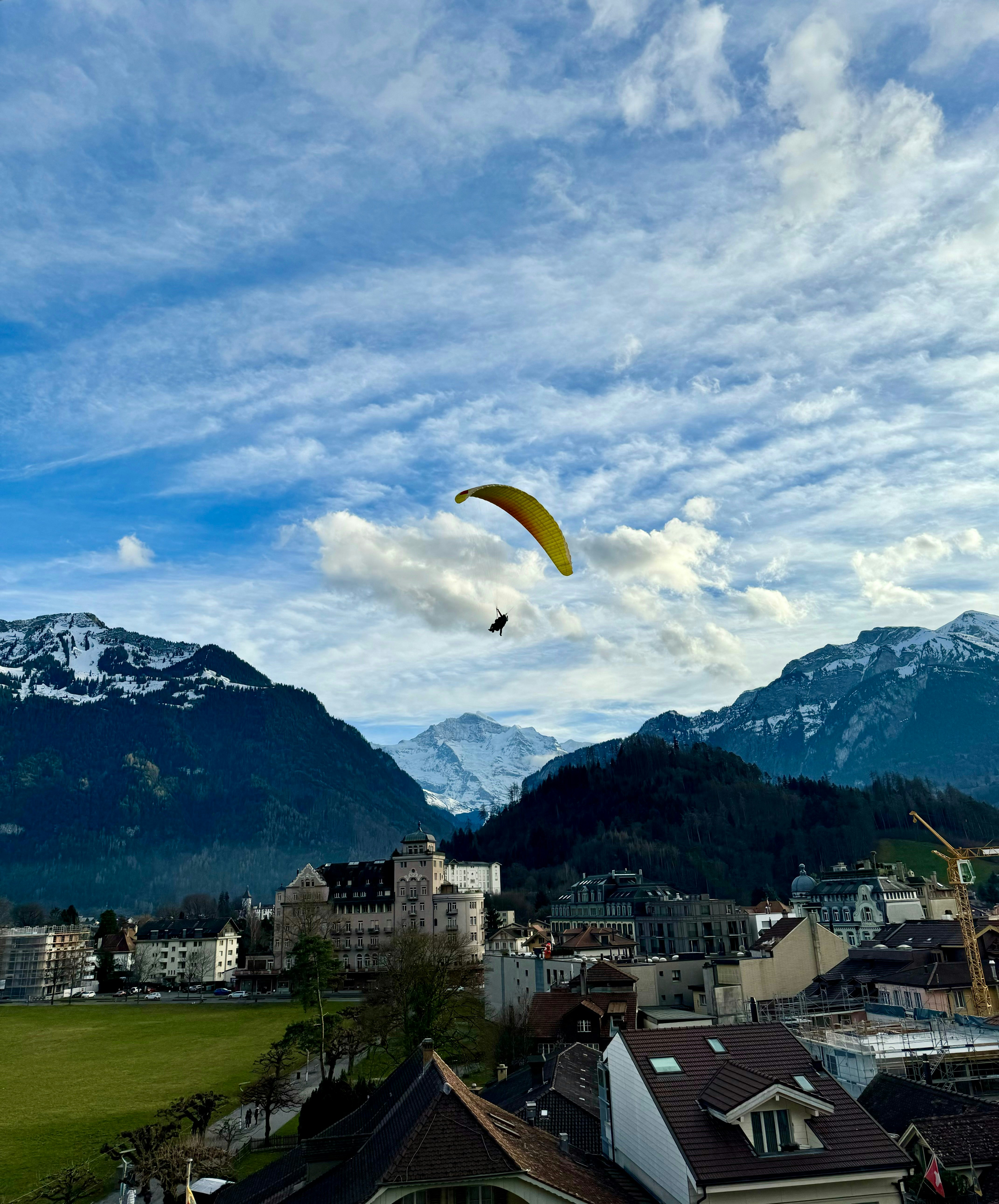 un cerf-volant volant au-dessus d’une ville avec des montagnes en arrière-plan