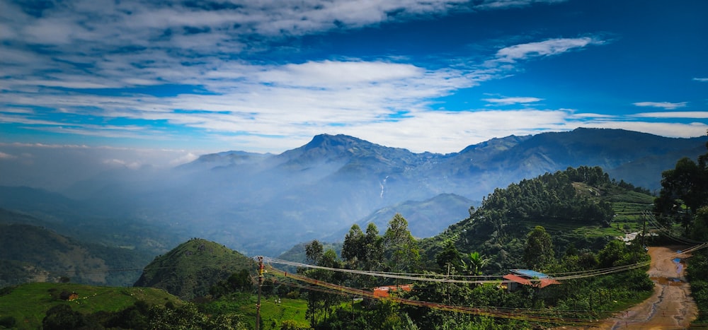 a view of a mountain range with a rope bridge in the foreground