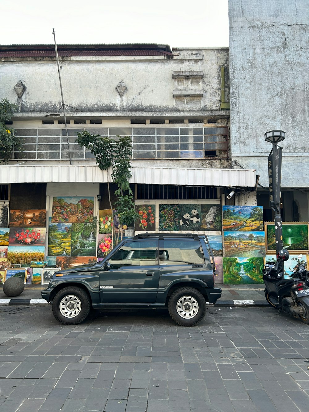 a car parked in front of a building with paintings on it