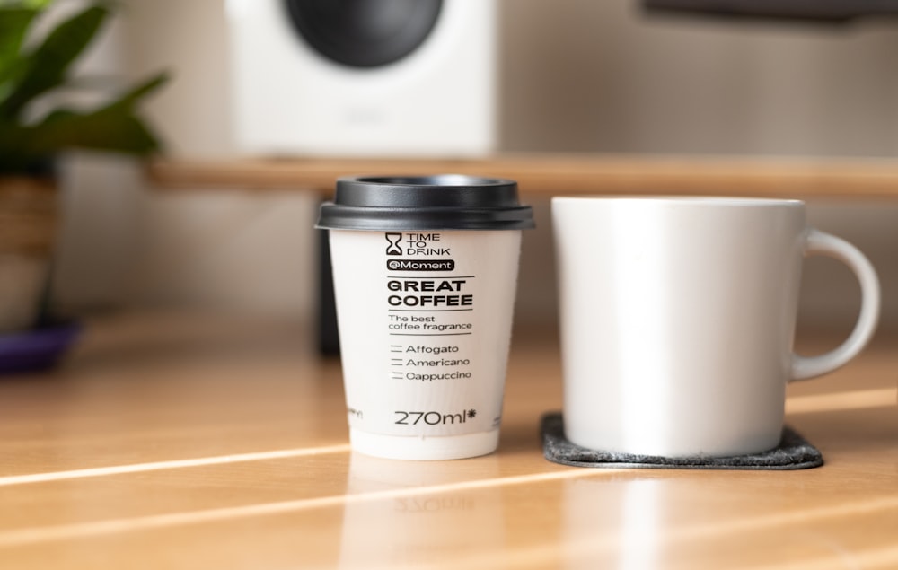 a cup of coffee sitting next to a coffee mug