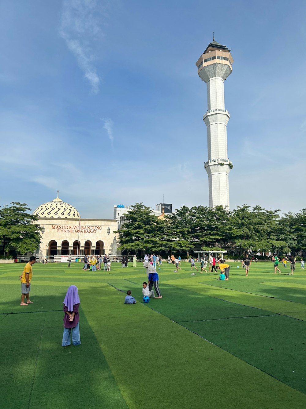 a group of people standing on top of a lush green field