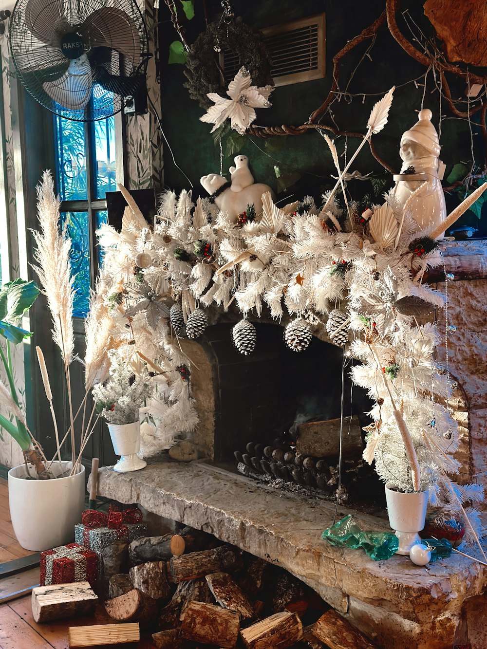 a fireplace decorated with white flowers and pine cones