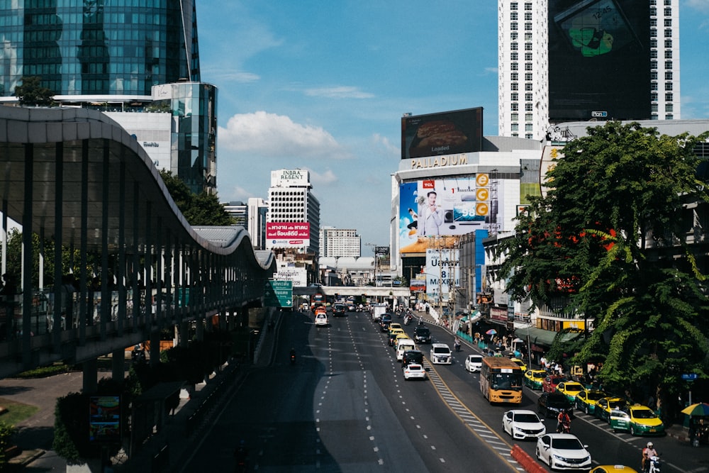 a city street filled with lots of traffic next to tall buildings